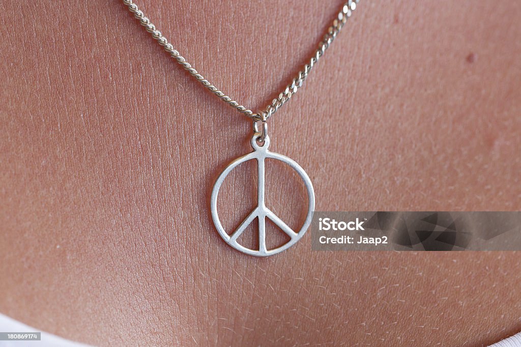 Macro close-up di collana in argento con Simbolo della pace sul petto - Foto stock royalty-free di Simboli della pace