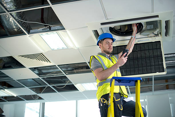 istock electrician fitting air conditioning to office interior 180869314
