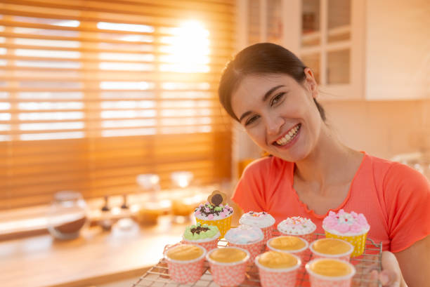 istock Asian woman shows off freshly made cupcakes in the kitchen 1808752443
