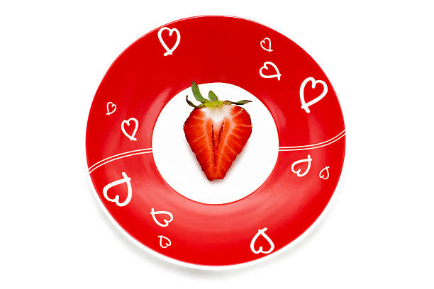 Deliciously half a red strawberry on the romantic red plate