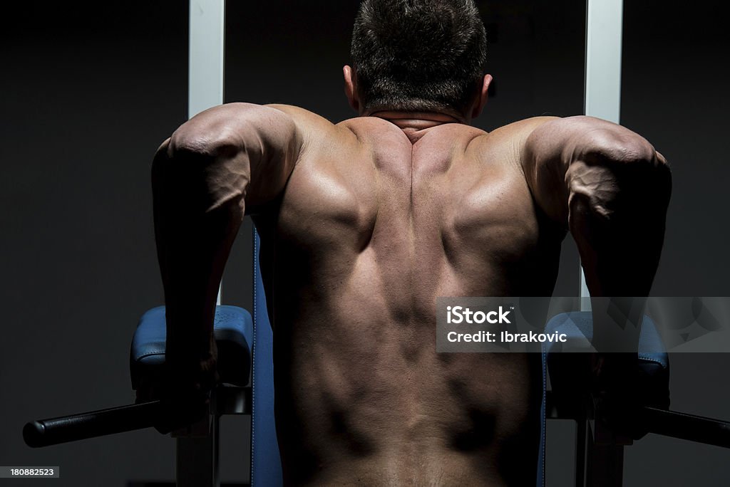 Jovem macho fazendo exercícios de peso pesado bodybuilder - Foto de stock de Academia de ginástica royalty-free