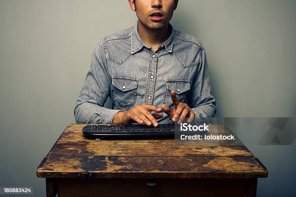 Man Typing On Keyboard At Old Desk Stock Photo - Download Image Now - Adults Only, Asian and Indian Ethnicities, Blue-collar Worker