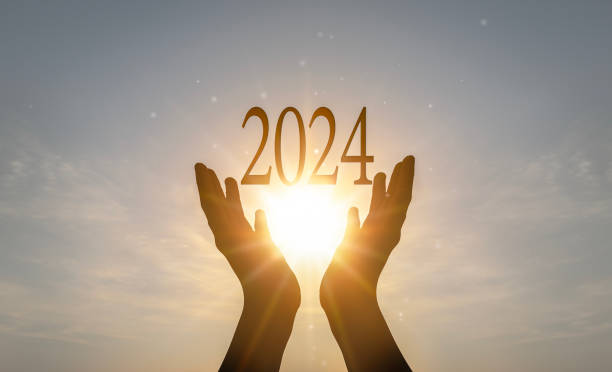 istock 2024 concept: Hands hold 2024 against on sunset background 1808836617
