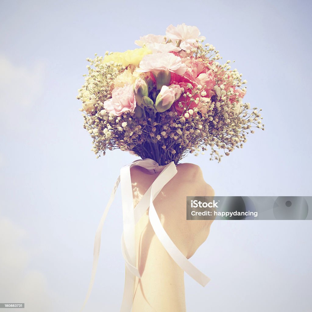Ramo de flores y cielo azul en la mano - Foto de stock de Buqué libre de derechos