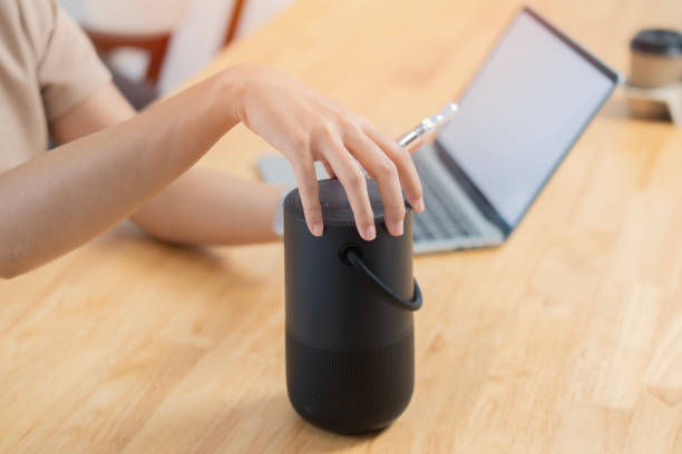 istock Selective focus of woman hand with laptop using voice assistant speaker at home office. 1808839868