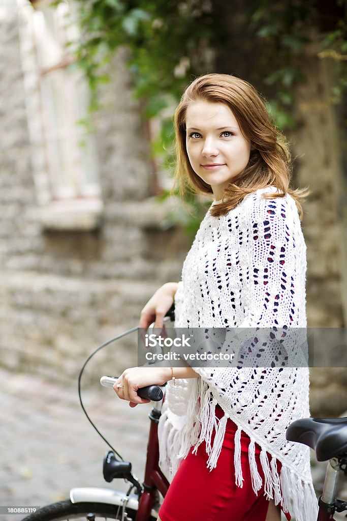 Mulher em vermelho Segure firme depois de bicicleta - Foto de stock de Adulto royalty-free