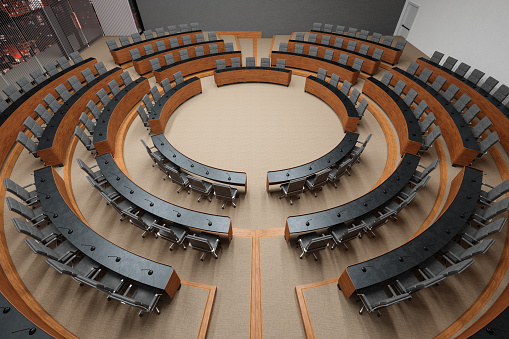 High Angle View Of An Empty Conference Hall With Gray Color Seats, Microphones On The Desks And Carpeted Flooring