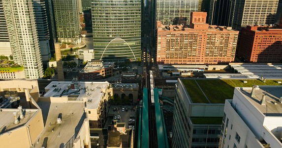 Aerial still image of train entering Clinton Station in Chicago, Illinois on a sunny day in Fall.