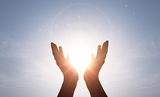 Human hands open palm up worship on sunrise background