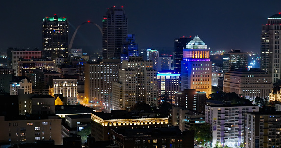 Aerial shot of Downtown St. Louis, Missouri on a hazy night in Fall, with the Gateway Arch visible between office towers.