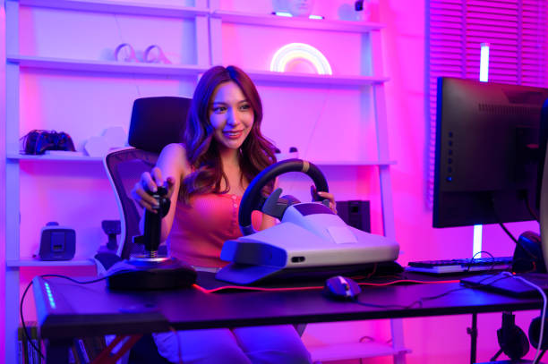 giovane donna graziosa asiatica pro gamer hanno live streaming giocando al videogioco, gioco di corse a casa - racing game foto e immagini stock