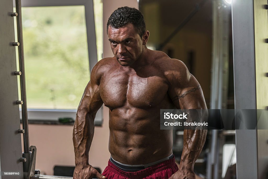bodybuilder maschio facendo esercizio di peso pesante per trap - Foto stock royalty-free di A petto nudo