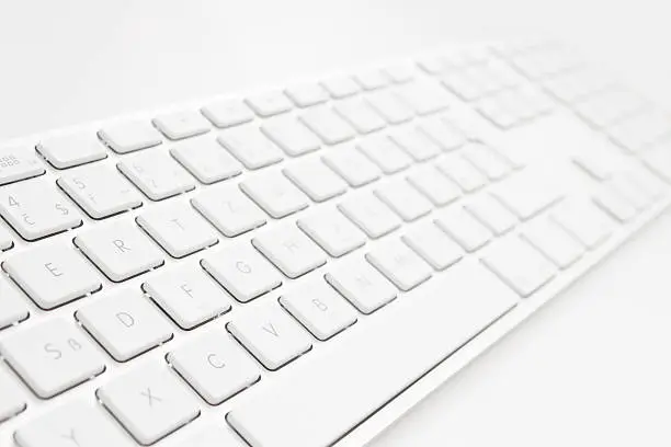 Photo of Close-up of an all-white keyboard over a white background