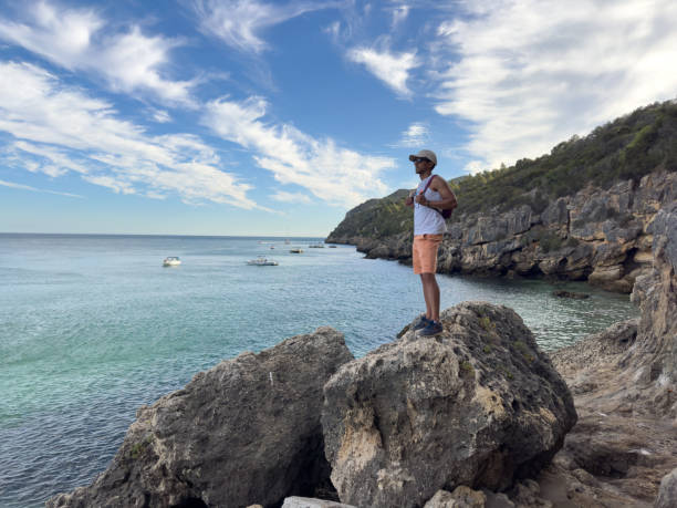 On top of a rock he watches the sea