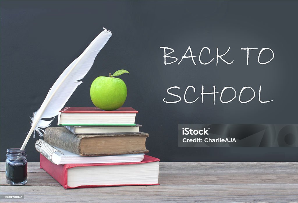 Back to school Back to school written on a chalkboard next to a pile of books Back to School Stock Photo