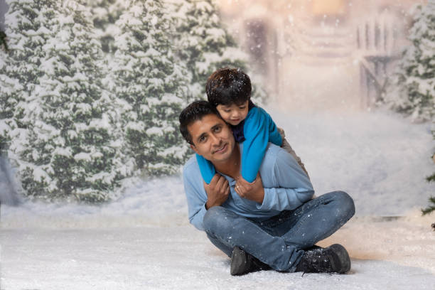 Mexican son hugging his father and laughing on christmas background