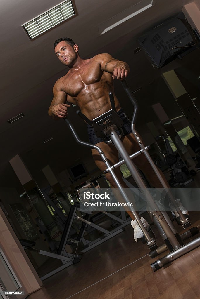 Мужской bodybuilder используя эллиптический тренажер - Стоковые фото Активный образ жизни роялти-фри