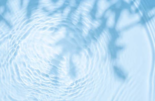 istock Background summer natural blue texture, clear water with ripples and splashes. Water waves in sunlight with leaf shadow, and background concept of cosmetics, moisturizer, and toner 1808970421