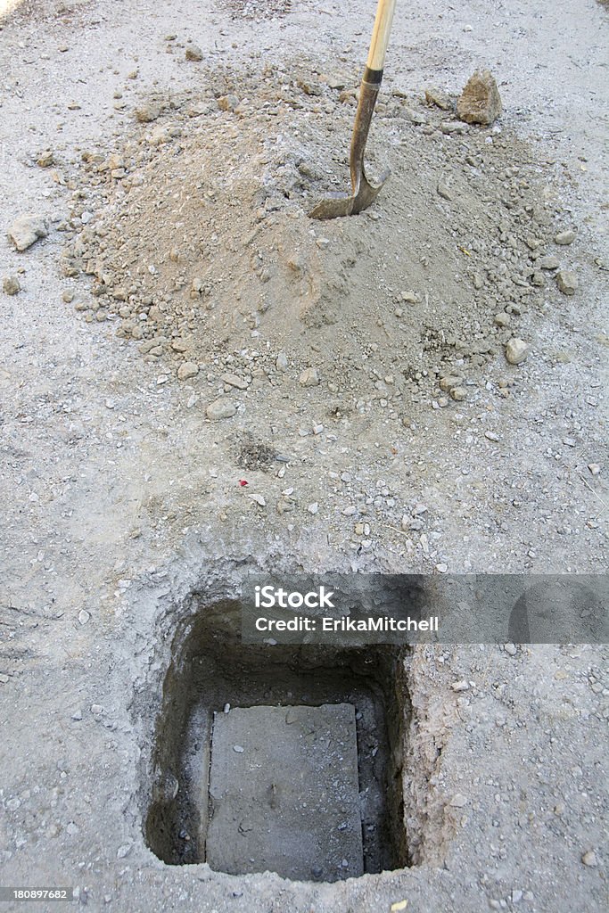 Septic tank lid with shovel and dirt pile This shovel was used to dig up the lid of a septic tank for pumping. Cement Stock Photo