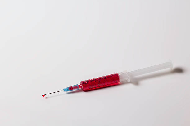 Syringe with drop of blood stock photo