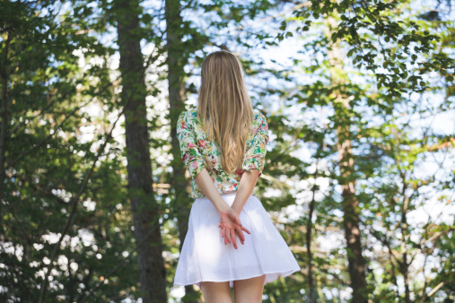 Blonde girl standing motionless in a forest