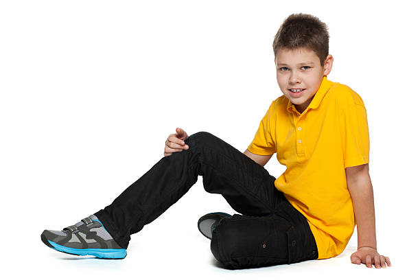 picture of curly 8 years old boy isolated on white. He is sitting. full length