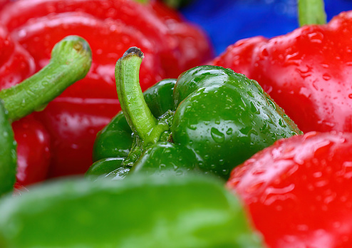 Green and red capsicums with raindrops