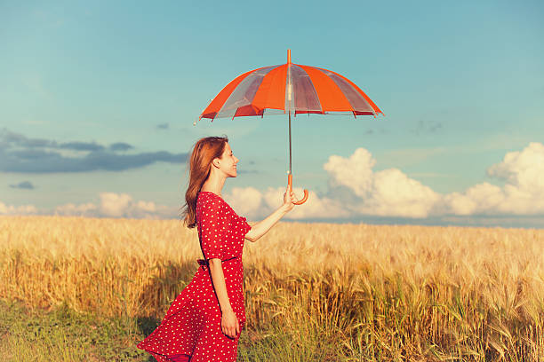 istock Redhead girl with umbrella at field 180903214