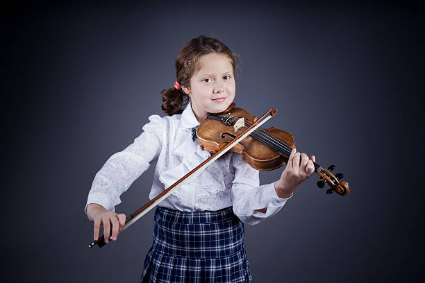 istock Beautiful girl playing the old violin on dark background 180903610
