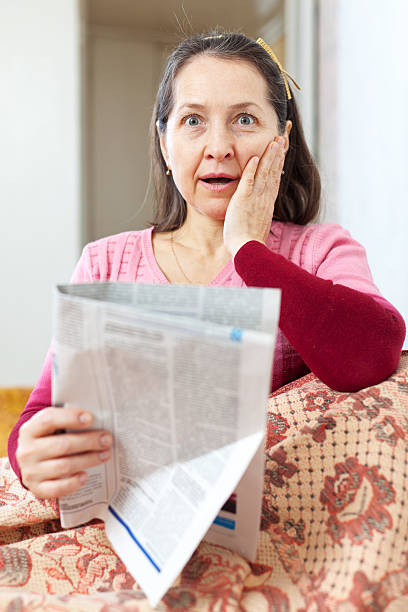 istock amazed mature woman with newspaper 180904072