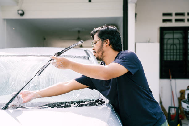 istock Young Man Washing His Car Using Water Jet at Home 1809063704