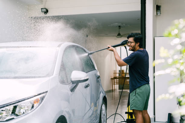 istock Young Man Washing His Car Using Water Jet at Home 1809064223