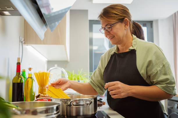 istock Woman cooking Italian spaghetti in her kitchen 1809066353