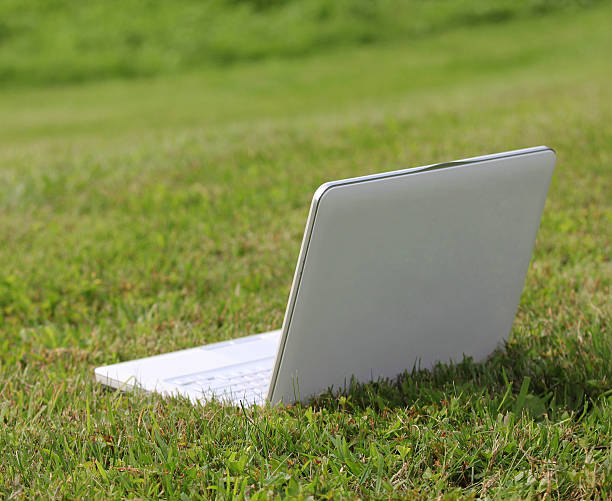istock laptop on the green grass 180907037