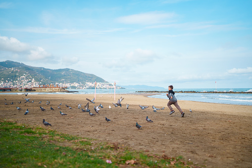 Little boy running at the beach next to sea