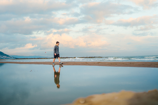 Teenage boy walking next to Black Sea Beach