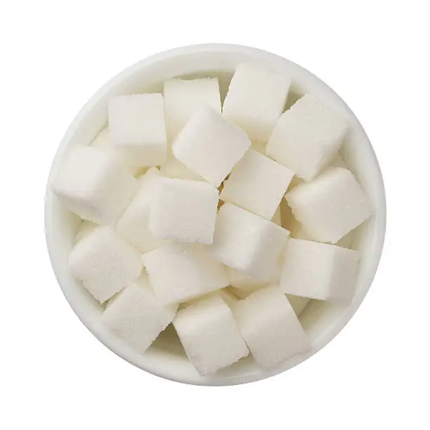 Sugar cubes in a bowl isolated on white
