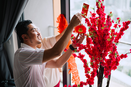 Asian Chinese son and mother preparing before Chinese New Year.