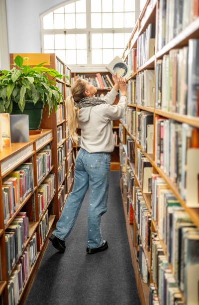 istock Student taking a book from shelf in the college library 1809111505
