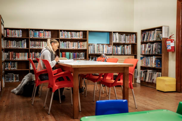 istock Young student sitting alone at table and studying in the college library 1809113087