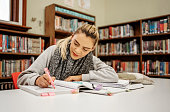 Young female college student studying in library