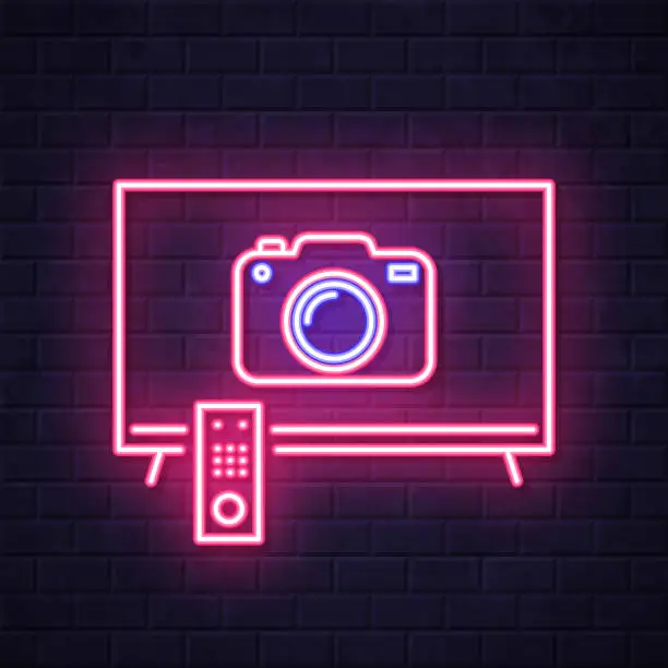 Vector illustration of TV with camera. Glowing neon icon on brick wall background