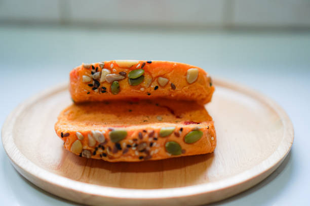 Front view of whole grain pumpkin bread arranged on a wooden dinner plate.