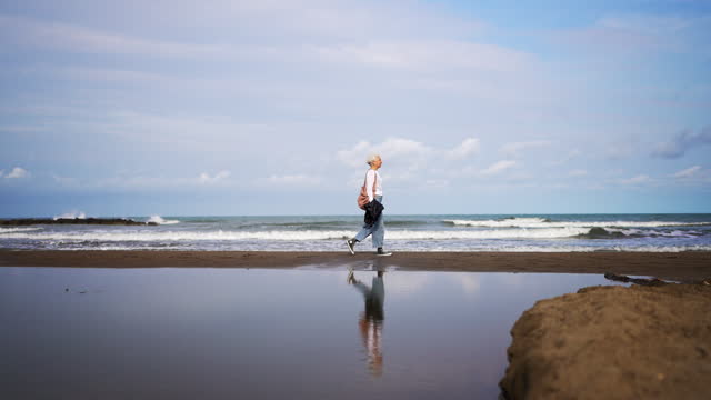 Woman walking at the coastline next to sea