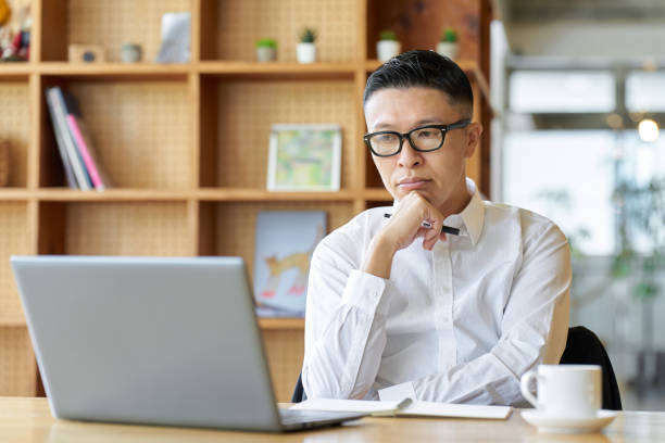 istock Asian businessman thinking while working at a cafe 1809140415