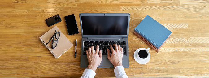 Hands of a businessman typing on a laptop