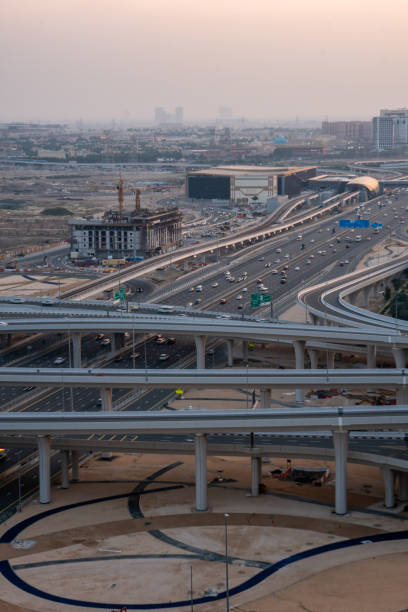 istock Large motorway and interchange road in a desert landscape, with constructions of buildings nearby, hazy and polluted skies. 1809140965