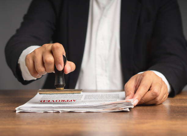 istock Businessman stamped approved on a document while sitting in the office 1809149063