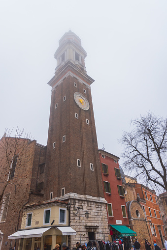 Venice, Italy - February 16 2023: The bell tower with clock of the Church of the Santi Apostoli (Holy Apostles), UNESCO world heritage site, Veneto, Europe