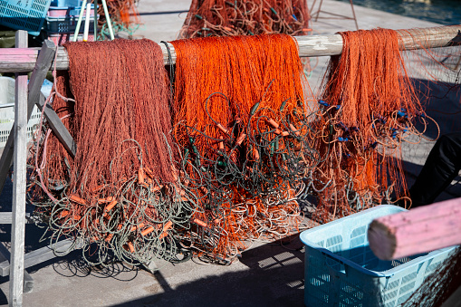 Nachikatsuura, Japan; 1st October 2023: Fishermen mending their fishing nets at Katsuura Harbor in Wakayama.
